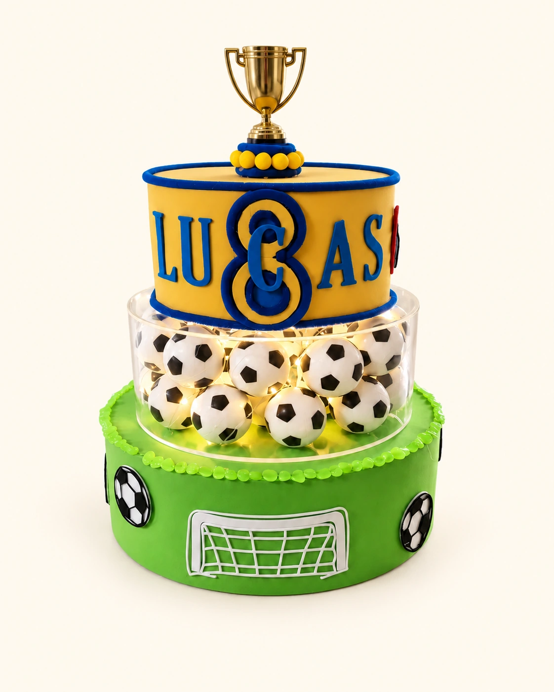 Creazione di compleanno per Lucas: coppa dorata, numero otto, palloni illuminati e base verde con porta da calcio.